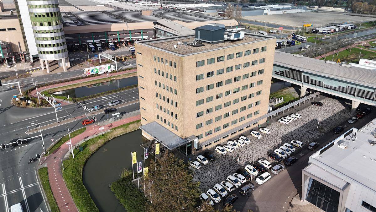 Luchtfoto van Horti Hotel, een kantoorgebouw van lichte baksteen aan het water