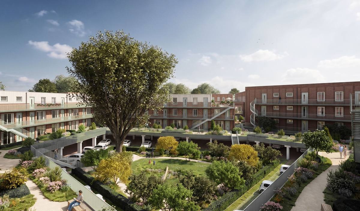 Impressie van de groene binnentuin van Dok District, Boeg, met een grote boom en galerijen rondom